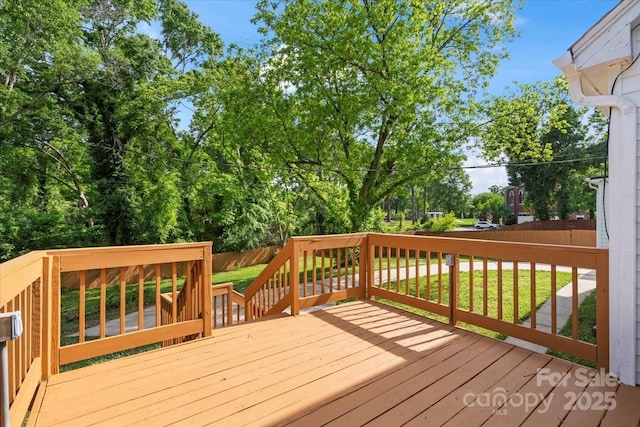 wooden terrace featuring a lawn and a fenced backyard