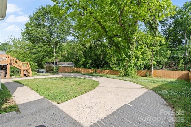 view of yard featuring fence and stairs