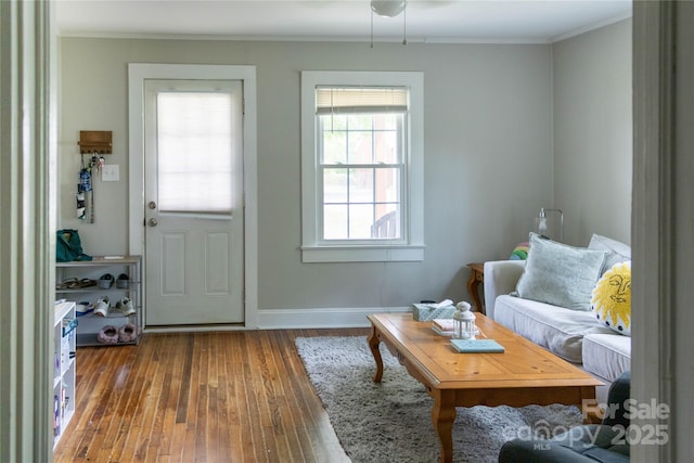 interior space with crown molding, baseboards, and hardwood / wood-style flooring