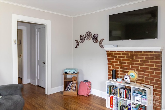 sitting room with baseboards, crown molding, and wood finished floors