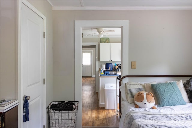 bedroom with ornamental molding and wood finished floors