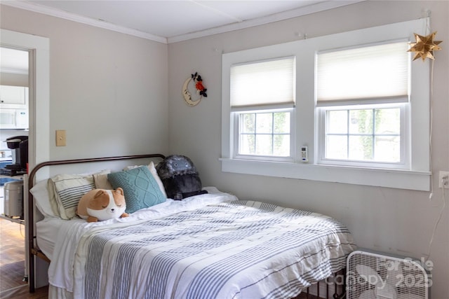 bedroom featuring crown molding and wood finished floors