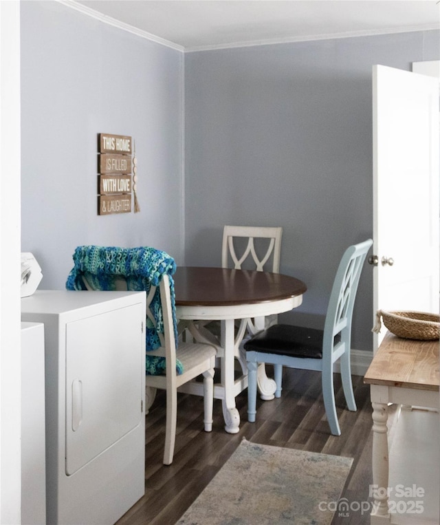 dining room featuring washing machine and clothes dryer, ornamental molding, and wood finished floors
