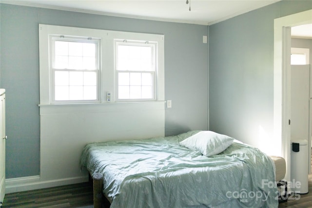 bedroom featuring crown molding, baseboards, and wood finished floors