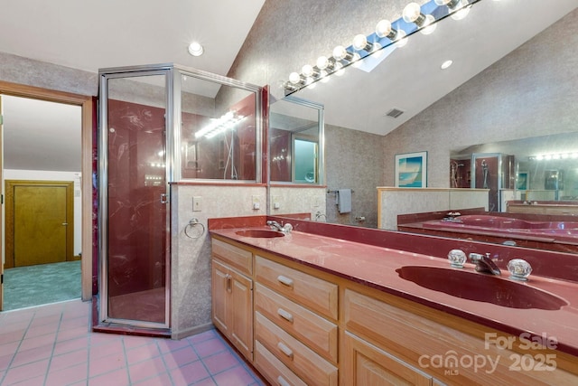 bathroom with a shower stall, tile patterned floors, a sink, and vaulted ceiling