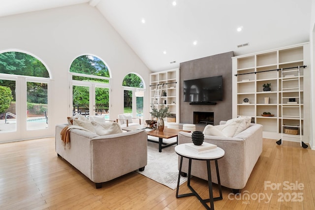 1245 Bellemeade Ln, Charlotte, NC 28270 - living room with high vaulted ceiling, a large fireplace, light wood-style flooring, recessed lighting, and french doors