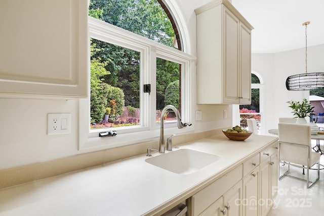 1245 Bellemeade Ln, Charlotte, NC 28270 - kitchen with a sink, light countertops, cream cabinetry, and decorative light fixtures