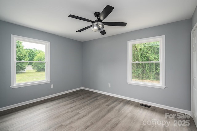1428 E Main St, Cherryville, NC 28021 - empty room with healthy amount of natural light, wood finished floors, a ceiling fan, and baseboards
