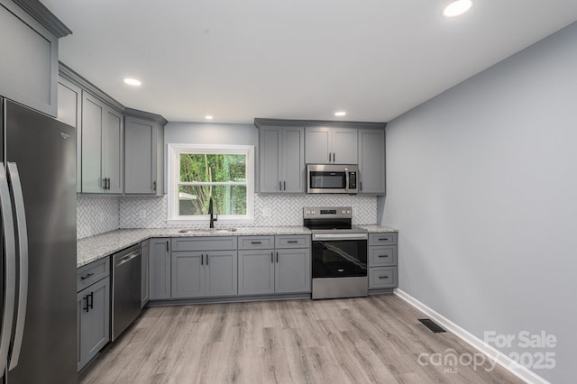 1428 E Main St, Cherryville, NC 28021 - kitchen featuring appliances with stainless steel finishes, a sink, gray cabinets, light wood-style floors, and recessed lighting