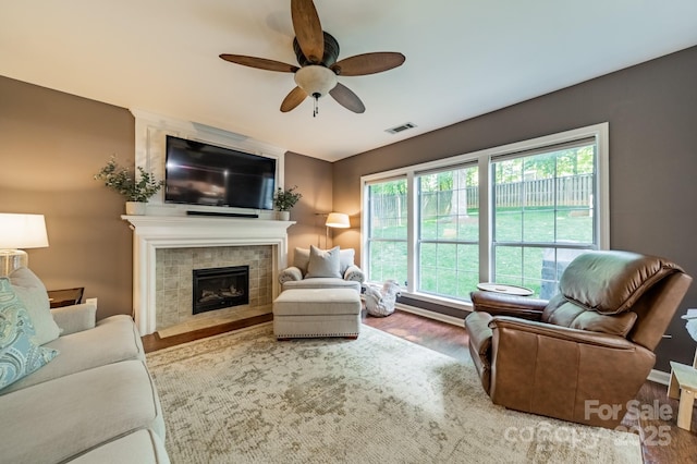 4201 Beauvista Dr, Charlotte, NC 28269 - living room with a tiled fireplace, visible vents, wood finished floors, and ceiling fan