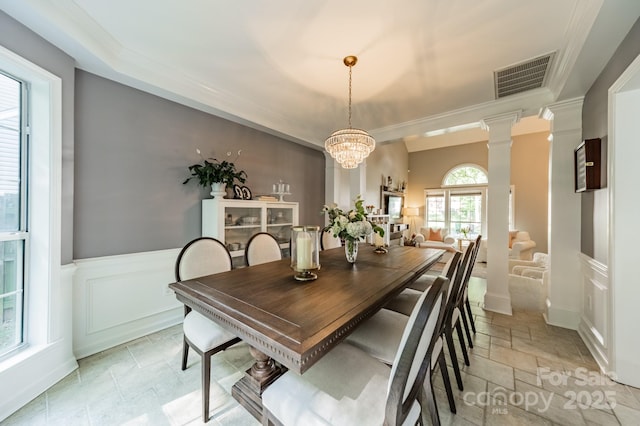 4201 Beauvista Dr, Charlotte, NC 28269 - dining room featuring stone tile flooring, ornamental molding, visible vents, wainscoting, and a notable chandelier