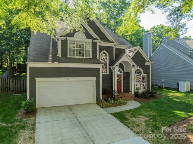 4201 Beauvista Dr, Charlotte, NC 28269 - view of front facade with a chimney, fence, an attached garage, concrete driveway, and a front yard