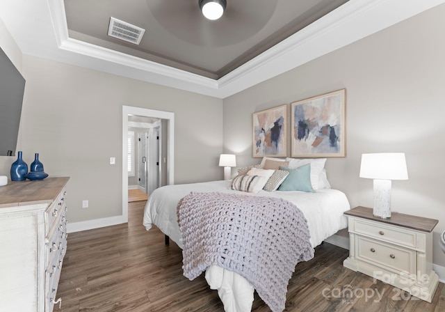 249 Landing Trl, Mount Gilead, NC 27306 - bedroom featuring visible vents, ornamental molding, baseboards, dark wood-type flooring, and a tray ceiling