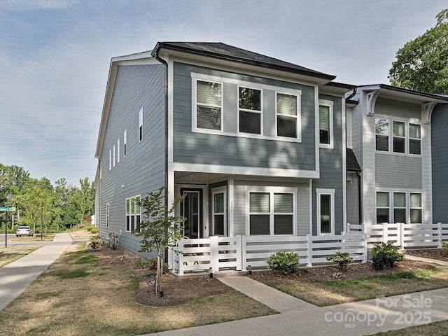 townhome / multi-family property with a porch and fence