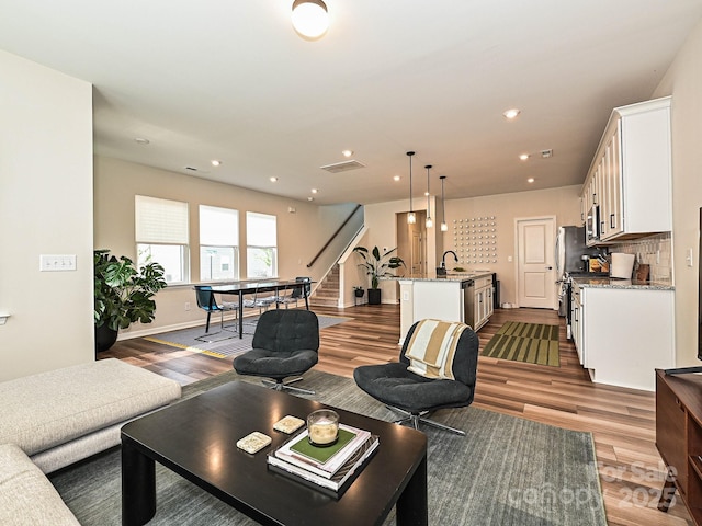 living room featuring baseboards, dark wood-style flooring, stairway, and recessed lighting