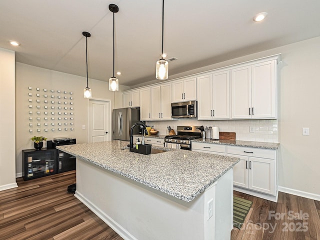 kitchen with a sink, white cabinetry, dark wood-type flooring, and appliances with stainless steel finishes