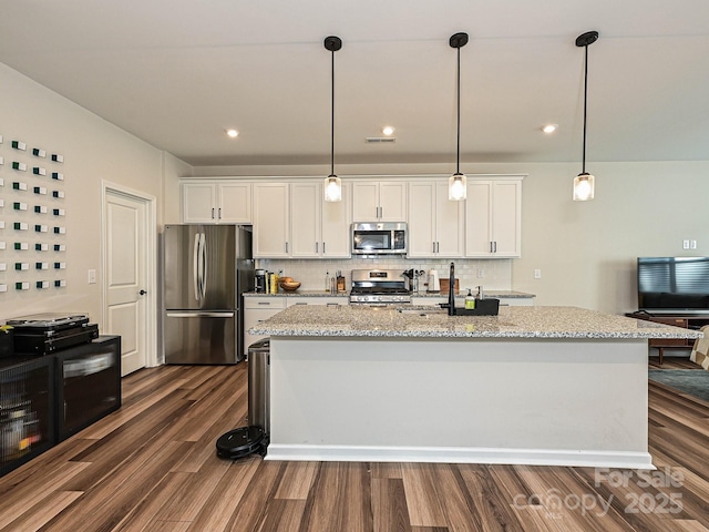 kitchen with dark wood-style flooring, tasteful backsplash, white cabinetry, and appliances with stainless steel finishes