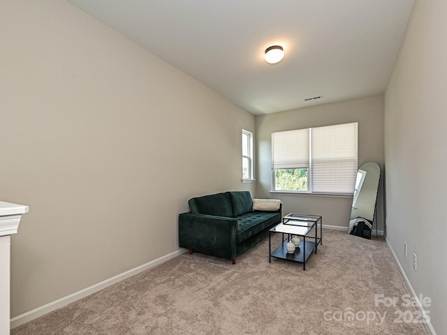 living area featuring carpet floors, baseboards, and visible vents