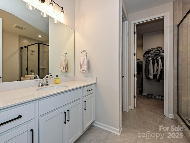 full bath with a walk in closet, tile patterned floors, visible vents, a shower stall, and vanity