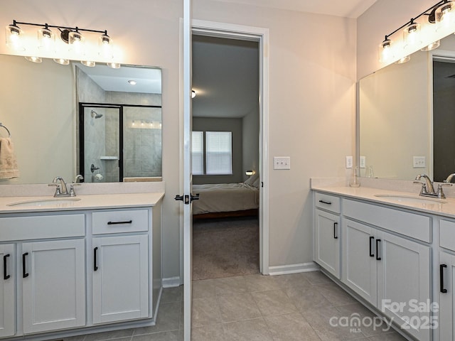 bathroom with a stall shower, tile patterned flooring, two vanities, and a sink