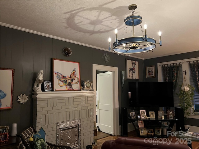 living area with crown molding, a chandelier, and wood finished floors