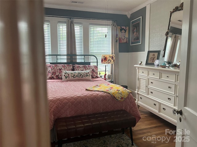 bedroom featuring crown molding, dark wood-style floors, and a wainscoted wall