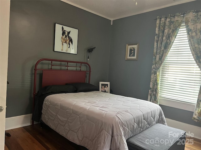 bedroom with baseboards, multiple windows, and wood finished floors