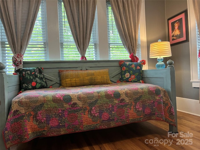 bedroom featuring baseboards and wood finished floors