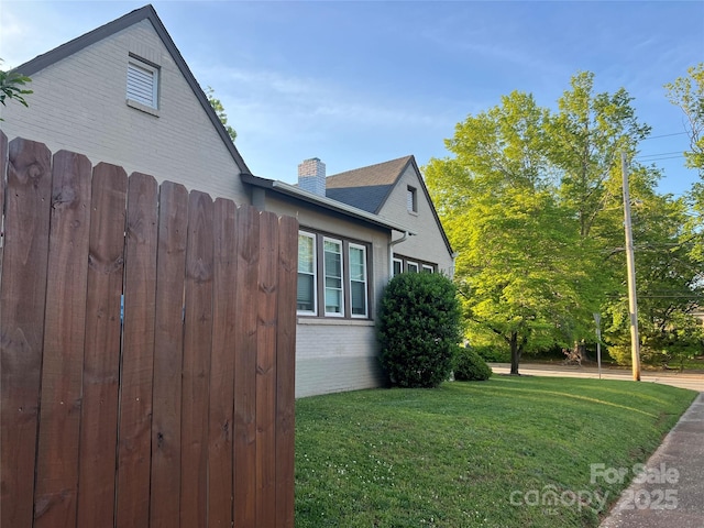 130 Arlington St, Forest City, NC 28043 - view of side of home with brick siding, a lawn, and a chimney