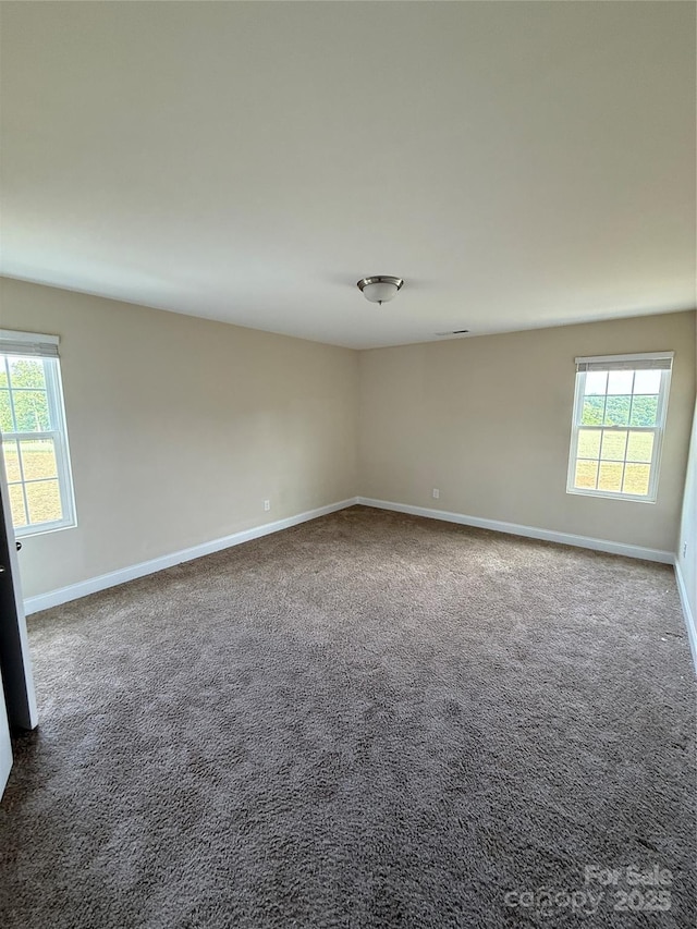 unfurnished room featuring baseboards and carpet