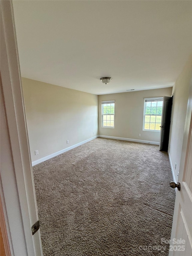 carpeted spare room with baseboards