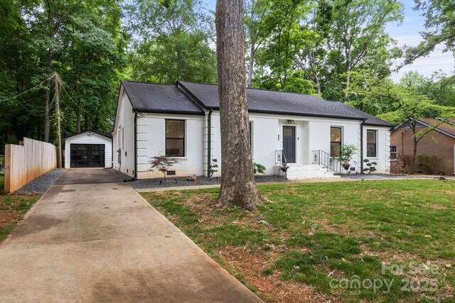 view of front of property with driveway, brick siding, a detached garage, an outdoor structure, and a shingled roof