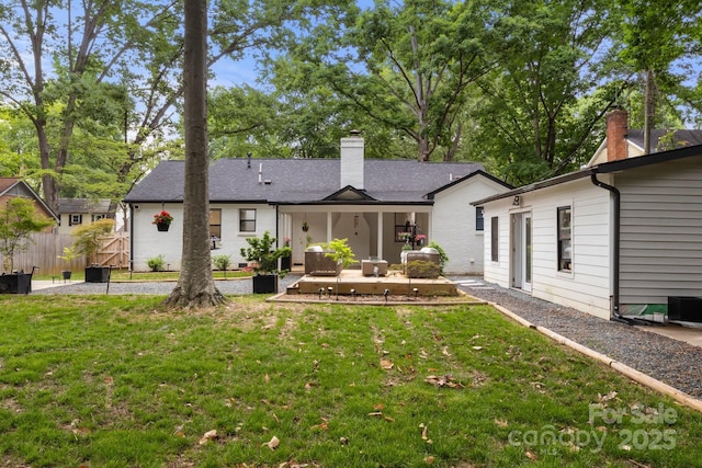rear view of property featuring a chimney and a patio