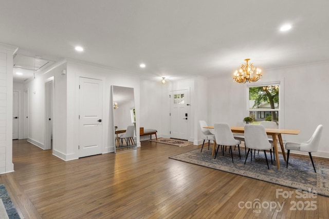 dining space with attic access, wood finished floors, recessed lighting, a chandelier, and crown molding