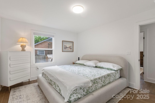 bedroom featuring wood finished floors and baseboards