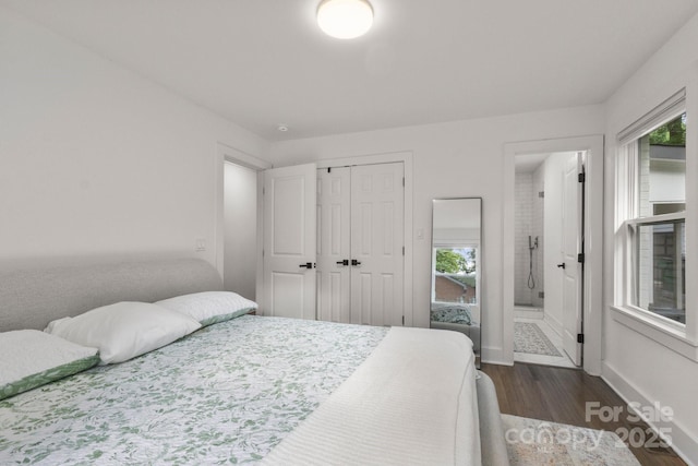 bedroom with dark wood-type flooring, multiple windows, a closet, and baseboards