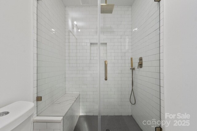 full bathroom featuring a stall shower and toilet