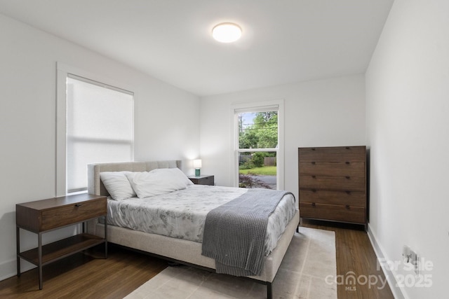 bedroom featuring wood finished floors and baseboards