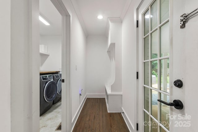 clothes washing area featuring washer and clothes dryer, wood finished floors, and baseboards