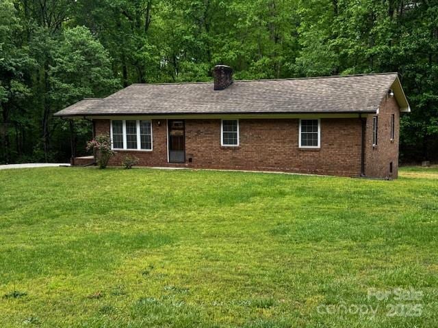 single story home with brick siding, a front lawn, roof with shingles, and a chimney