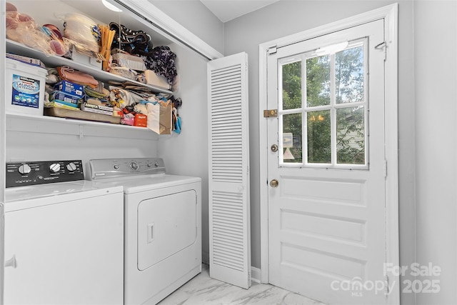 clothes washing area featuring washer and clothes dryer and light marble finish floors
