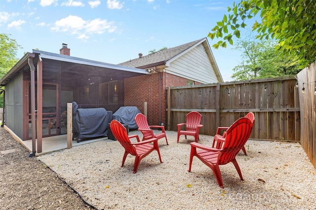 view of patio / terrace featuring a sunroom, fence, and a grill