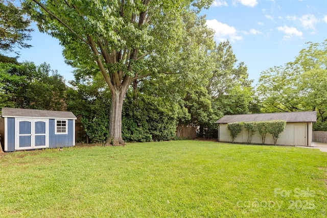 view of green lawn with a storage unit and an outbuilding