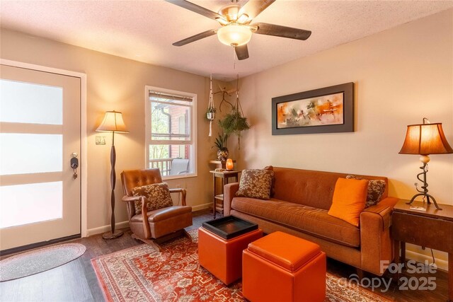 living room with baseboards, ceiling fan, and wood finished floors