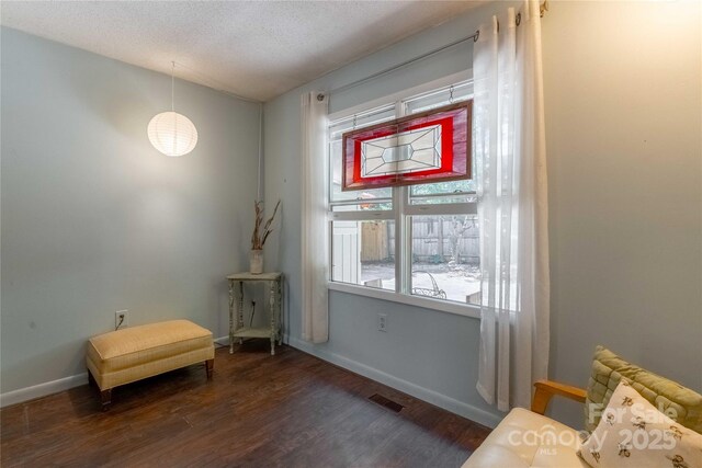 sitting room featuring a textured ceiling, baseboards, visible vents, and wood finished floors