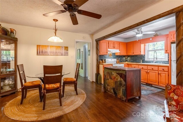 kitchen with ceiling fan, white appliances, dark wood-type flooring, backsplash, and under cabinet range hood