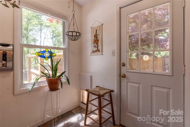 doorway to outside featuring baseboards