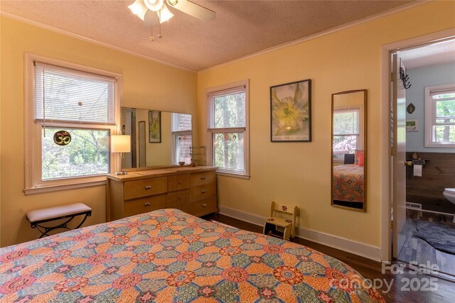 bedroom with a textured ceiling, ornamental molding, baseboards, and wood finished floors