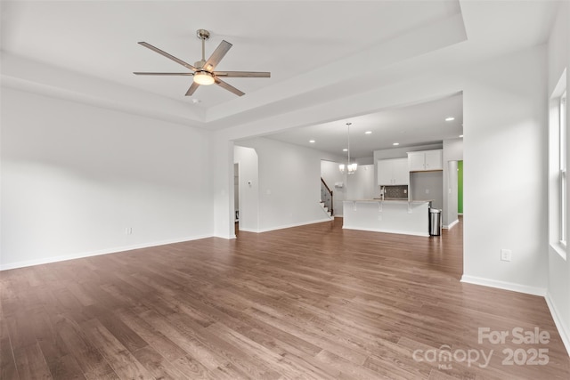 423 Shallowford Dr, Rock Hill, SC 29732 - unfurnished living room featuring a raised ceiling, wood finished floors, recessed lighting, ceiling fan, and stairway