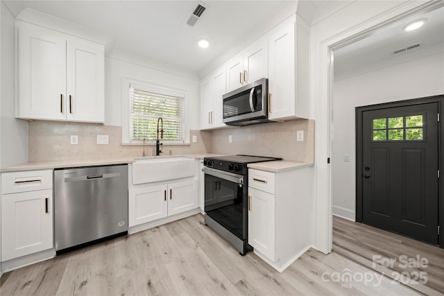 kitchen with visible vents, light wood-style floors, a wealth of natural light, and stainless steel appliances